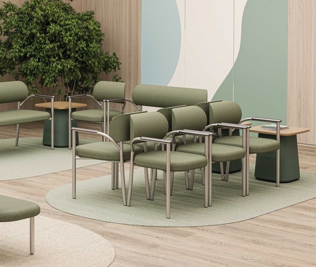 Coradle by MooreCo adult healthcare waiting room seating with green upholstered chairs, loveseat, and Add-A-Table side tables in a nature-inspired pediatric clinic environment